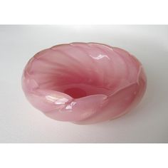 a pink glass bowl sitting on top of a white table