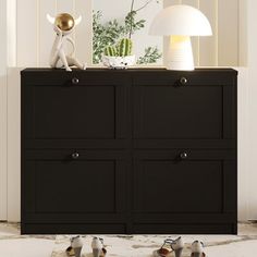 a black dresser with four birds on it and a lamp in the corner next to it