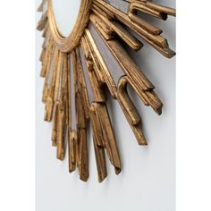 a mirror that is on the wall with some wood sticks hanging from it's sides