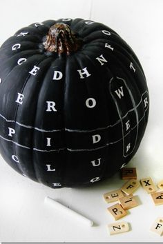 a black pumpkin with scrabbles around it and words written on the side