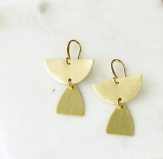 Semicircle Dangle Earrings, Brass Teardrop Earrings, Brass Half Circle Earrings, Gold Minimalist Earrings, Gold Tribal Earrings, Geometric A pair of small geometric style earrings made from natural, golden brass that has been sealed to protect the finish. Simple, trending style and a lightweight pair of everyday brass dangle earrings. * Drop length 1 inch * Natural brass that has been sealed * Lightweight * Unique handmade ear wires www.etsy.com/shop/heatherberry http://www.facebook.com/pages/He Gold Triangle Minimalist Earrings, Minimalist Gold Triangle Earrings, Minimalist Triangle Nickel-free Earrings, Minimalist Nickel-free Triangle Earrings, Gold Geometric Earrings For Everyday, Nickel-free Geometric Brass Earrings, Minimalist Triangle Brass Jewelry, Minimalist Brass Dangle Earrings, Geometric Brass Earrings