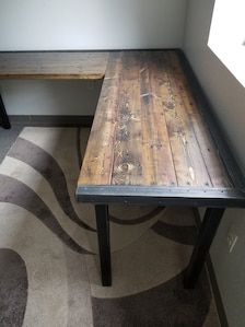 a wooden table sitting next to a metal bench on top of a carpeted floor