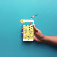 a hand holding an iphone with a birthday cake on the screen and two lemons sticking out of it