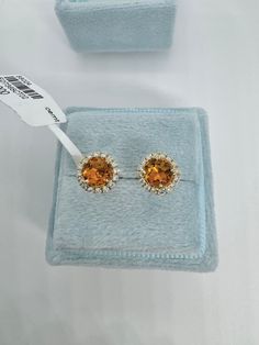 Beautiful Round Halo Citrine and Diamond Stud Earrings Yellow Gold.  Simple and classy earrings.  Excellent craftsmanship, the halo of diamonds frame the citrine beautifully.  The diamonds are very sparkling.  The halo measures about 7.7mm.   The push backings have 2 security notches for a secure fit.  The backs are big and strong.   Genuine citrine 5mm round cuts  Total weight: 0.87 carats Genuine round brilliant cut diamonds  Total weight: 0.23 Clarity: SI Color: G Solid 18K Yellow Gold 2.13 grams  Comes with gift box AT1700 * We have been in the wholesale Jewelry business for over 30 years serving the community at the same location.  All diamonds we use are natural stones and fine quality gold.  Absolutely NO clarity enhanced or treated diamonds. Our jewelry pieces are handcrafted with Orange Diamond Jewelry With Halo Setting, Gold Cluster Earrings With Halo For Formal Occasions, Formal Gold Cluster Earrings With Halo, Gold Halo Cluster Earrings For Formal Occasions, Gold Halo Cluster Earrings For Formal Events, Luxury Topaz Earrings For Wedding, Yellow Gold Halo Cluster Earrings For Wedding, Formal Yellow Gold Cluster Earrings With Halo Setting, Formal Orange Gemstone Earrings