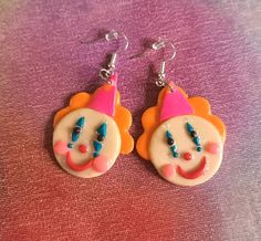 a pair of earrings with clown faces on them