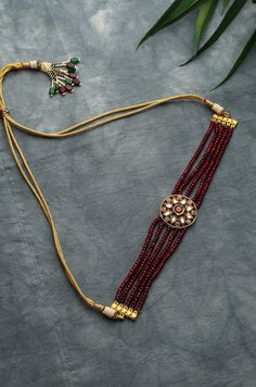 This choker boasts of rich red stones with a floral kundan unit at the centre. This piece made to wrap beautifully aound your neck is replete with traditionality and contemporary charm. Necklace Closure - Adjustable Dori Style Tip - Being a strong supporter of the intersection of classic and contemporary, we love designs that are contemporary yet boast hints of traditional charm. This choker can be a great pair for traditional sarees, indo-western dresses or even a power suit. Handcrafted in Jam Moti Set, Choker Necklace Gold, Choker Necklace Designs, Choker Designs, Antique Jewellery Designs, Gold Jewelry Simple Necklace, Kundan Choker, Pearl Necklace Designs, Red Stones