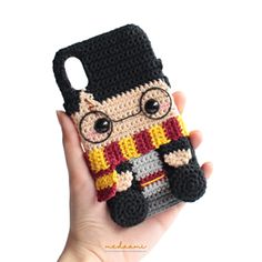 a hand holding up a phone case made to look like harry potter