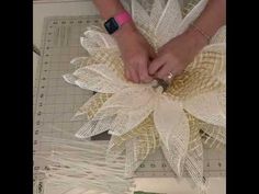 a person is cutting fabric with scissors on a piece of paper that has been made into a flower