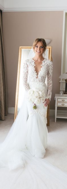 a woman in a wedding dress standing next to a mirror