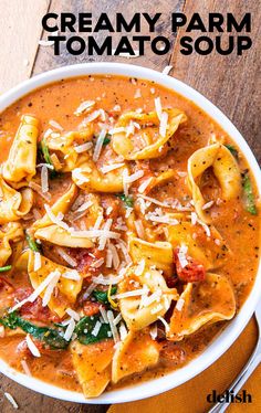 a bowl of creamy parm tomato soup with tortellini shells and spinach