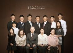 a group of people posing for a photo in front of a brown wall with the words photo house written on it