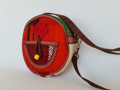 Handmade Carpet Bag Purse, tribal round crossbody, with a cute leather flower and yellow wood bead accent. Large enough to hold your change, keys or any small items.  You can also wear it on shoulder. Exterior Design: handwoven Kilim  Interior Design: Bag Lining No inside pocket Nubuck Leather Strap adjustable to 51" / 129 cm Brass Hardware Size 16 cm x D 6 cm // 6 1/2" x D 2 1/2" All measurements are taken by Hand and are approximate. Slight variations may occur. Only 1 Available. This Item is Round Brown Shoulder Bag For Travel, Brown Round Shoulder Bag For Travel, Brown Round Bag For Daily Use, Bohemian Round Bag For Everyday Use, Handmade Round Bag For Everyday Use, Handmade Round Shoulder Bag For Everyday Use, Carpet Bag Purse, Circle Bag, Kilim Bag