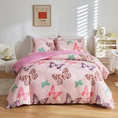 a bed with pink and green butterflies on it