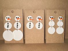 three snowmen made out of paper with tags on them