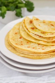 a white plate topped with tortillas on top of a table