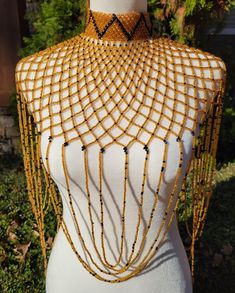 Beautifully beaded high collar body necklace. Primary color is gold with black beads placed throughout a diamond shaped web design with loop accents. The fit of this necklace is a high choker cascading down the chest with delicate loop details draping the arms and torso. Body necklace measurements are as followed: Front is 14.5 inches long (measured from top of the chocker neckline down the front of torso.  Side is 13.5 inches long (measured from shoulder and down the arm) and diameter of the po Cowrie Shell Jewelry, Necklace Measurements, Body Necklace, Back Chain, Blue Beaded Necklace, Bold Necklace, Mens Silver Necklace, Beaded Statement Necklace, Neck Piece