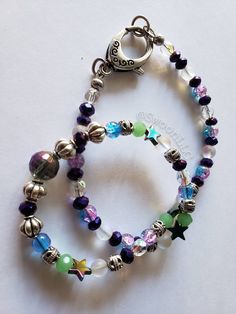 One of a kind handmade choker strung on super durable Beadalon steel wire. Beads are high quality with facets and iridescence. There is synthetic moonstone, faceted iridescent cobalt, faceted clear iridescent beads, silver plated decorative spacers, and star shaped glass beads that look mostly purple or teal depending on angle and lighting. Center has the largest glass bead with several facets and similar looking to a Disco Ball (replace mirrors with more iridescence). Measured laid flat against Iridescent Adjustable Round Bead Necklaces, Iridescent Adjustable Necklace With Round Beads, Adjustable Iridescent Choker Jewelry, Iridescent Spacer Beads For Jewelry Making, Iridescent Faceted Beads Bracelet As Gift, Iridescent Faceted Beaded Bracelets As Gift, Iridescent Faceted Beads Bracelet For Gift, Gift Iridescent Beaded Bracelets With Faceted Beads, Iridescent Bracelet With Faceted Beads For Gift