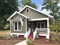 a small gray and white house with red steps