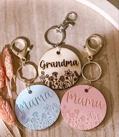 three personalized keychains with flowers and the word grandma written on one of them