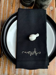 a napkin with the word mark written on it is sitting on a plate next to a fork and knife