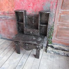 a wooden bench sitting in front of a red wall