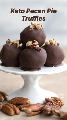 chocolate covered pecan pie truffles on a white cake plate with walnuts