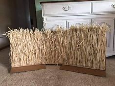 two pieces of straw sitting on top of a carpeted floor next to a dresser