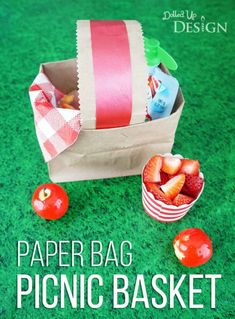 paper bag picnic basket with strawberries and cherries on the grass next to it