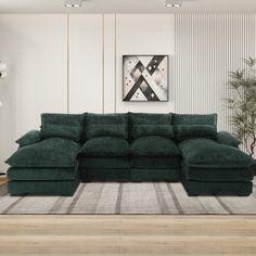 a large green sectional sofa in a living room with wood flooring and white walls