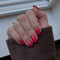 Holiday nails, red nail inspo, nail picture inspo, almond shaped acrylic nails, uv gel nails, bright red nails, little christmas bow on ring finger with rhinestone, holiday christmas nails, red christmas nails with bow, aesthetic nail photo, nail photo inspo Nail Inspo 2023 Christmas, Simple Christmas Nails No Design, Christmas Bow Nails Acrylic, Red Almond Nails With Bow, Red Nails With Ring Finger Design, Short Nail Design Christmas, Red Christmas Nails Short Almond, Christmas Natural Nail Designs, Red Nails With Pink Bow