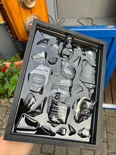 a person holding up a box with bottles in it