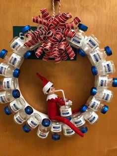 an elf is sitting on top of a wreath made out of water bottles