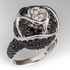 This edgy 18K white gold rose ring features one-hundred three round cut black onyx that are pavé set. In the center of the rose are three round brilliant cut diamond accents. It is currently a size 6.5. Elegant Black Spinel Diamond Ring, Elegant Black Diamond Round Cut Ring, Elegant Black Diamonds Round Cut Diamond Ring, Elegant Black Spinel Rings With Diamond Accents, Elegant Black Spinel Diamond Ring For Anniversary, Luxury Black Diamond Ring For Anniversary, Luxury Black Diamond Ring, Formal Black Diamond Round Ring, Elegant Black Cluster Ring For Formal Occasions