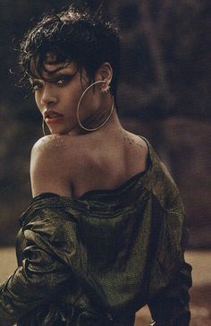 a woman sitting on the ground wearing large hoop earrings