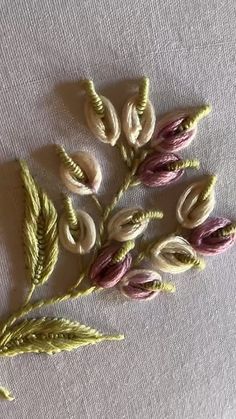 three different types of flowers on a white table cloth with green stems and purple petals