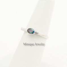 An Oval Shaped Alexandrite Color Changing Gem ring. The minimalist geometric-shaped ring is dainty and it has a simple yet elegant look. Sterling Silver An elegant and minimalist design with an Alexandrite Colored CZ ring. The gem is oval-shaped. We carry the same design with different gemstones also. 🎀 Material: Sterling Silver. 🎀 Dimensions: 🎀The bandwidth: 2 mm 🎀Gemstone: 6 mm X 4 mm 🎀Around 2. 20 grams. 🎀Finish: High polish with Rhodium plating. Please note that this is entirely hand-m Minimalist Oval Cabochon Opal Ring For Anniversary, Modern Oval Cabochon Opal Ring, Minimalist Opal Stackable Promise Rings, Minimalist Adjustable Opal Open Ring, Minimalist Opal Birthstone Ring, Minimalist Oval Cabochon Birthstone Ring, Minimalist Oval Moonstone Ring For Everyday, Minimalist Oval Opal Ring Gift, Minimalist Oval Opal Ring For Gift