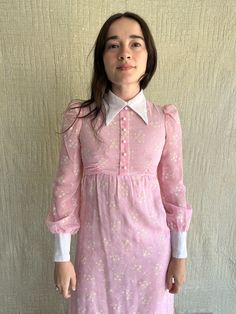 "70s Connie Sage Pink Floral Print Maxi Dress  / Back Zipper/ Waist Tie in Back/ Hook & Eye Closure at Back Neck of Collar / Flocked White Floral Print/ Semi Sheer / Original Buttons at Front and Cuffs Measurements: Size XXS-XS LAID FLAT 100% Cotton Waist: up to 26\" Chest: up to 32\" Shoulder: 12\" Sleeve Length: 25 1/2\" Front Length from HPS: 54\" Condition: Great Vintage Condition PLEASE READ BEFORE PURCHASE :  ALL SALES ARE FINAL" Spring Mini Dress With Peter Pan Collar, Retro Collared Mini Dress For Spring, 1970s Long Sleeve Dresses For Spring, Vintage Collared Party Dress, 1970s Style Long Sleeve Dresses For Spring, Vintage Collared Dress For Parties, Pink Retro Dress With Peter Pan Collar, Vintage Long Sleeve Mini Dress For Spring, Vintage Mini Dress For Fall