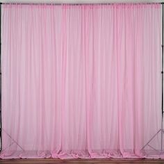 a pink curtain is hanging on the side of a wall with two spotlights in front of it