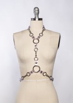 The Industrial Chained Harness pairs PVC and metal hardware together, showcasing it in a way that allows it to stand out and be the main event.Buckles at neck and waist.Chains and o-rings are linked together with black PVC. Because of the oversized hardware, this piece has a nice weight to it.Silver toned industrial hardware. On-model photo shows this harness in clear PVC layered with the Industrial Draped Chain Set.Custom sizing available. All pieces are MADE TO ORDER, standard sizes XS-XXL or Mischief Aesthetic, Gel Photography, Colour Gel Photography, Christian Cowan, Harness Fashion, Chain Harness, Random Character, June Bug, Cyberpunk Fashion