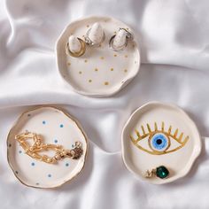 three porcelain dishes with eye charms on them