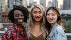 three women standing next to each other in front of a cityscape with skyscrapers