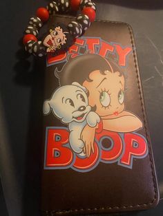 a wallet with a cartoon character on it and a beaded bracelet attached to it