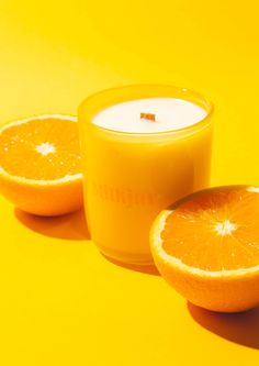 an orange cut in half next to a candle