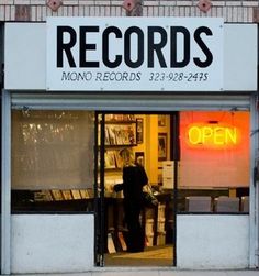 a record store with an open sign on the front door and windows that read records