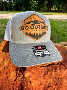 Premium leatherette patch hat on Richardson 112 trucker style hat. Snap back closure.  Go Outside (Romans 1:20) laser engraved design on premium Lonestar Leatherette.  Can make custom logo orders. Message seller for quotes. Currently available in grey/black, grey/white, Black/white, navy/khaki, Camo/black, and Camo/khaki. Many other hat options available upon request. Trucker Baseball Cap With Letter Patch For Outdoor, Outdoor Trucker Baseball Cap With Letter Patch, Outdoor Trucker Hat With Letter Patch And Curved Brim, Baseball Season Trucker Hat With Flat Bill For Outdoor, Baseball Season Trucker Hat With Flat Bill, Flat Bill Trucker Hat For Baseball Season, Brown Trucker Hat With Letter Patch For Outdoor, Outdoor Hats With Letter Patch And Curved Brim, Outdoor Cap With Letter Patch