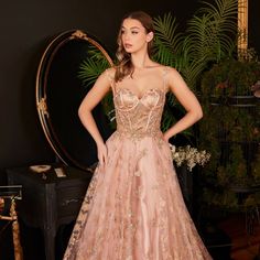 a woman in a pink dress standing next to a mirror