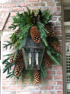 a brick wall with a lantern and pine cones on it