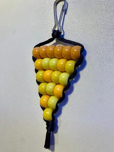 an earring made out of candy corn on the cob is hanging from a hook