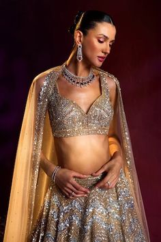 Gold attached cancan lehenga with silver sequin, crystal, bugle bead embroidery in chevron pattern. Paired with sweetheart neck embroidered padded blouse and dupatta. - Aza Fashions Glamorous Wedding Sharara With Unstitched Blouse, Glamorous Choli With Zari Work For Celebration, Glamorous Wedding Lehenga For Navratri, Glamorous Wedding Sets With Unstitched Blouse, Festive Silver Glamorous Choli, Glamorous Silver Sets For Festive Season, Glamorous Silver Festive Sets, Glamorous Festive Silver Set, Glamorous Celebration Sets With Mirror Work