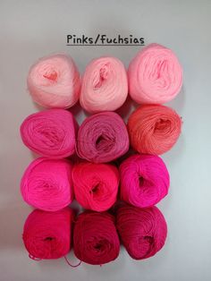 six skeins of pink and orange yarn on a white surface with the words pink / fuchsias written above them